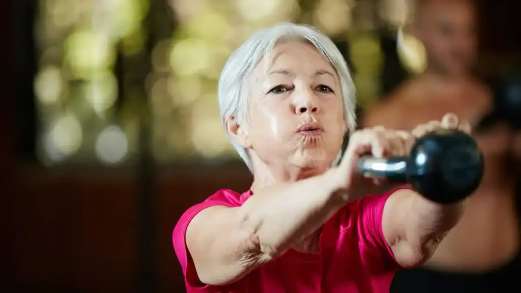 Older woman doing weight training Harrogate to help her strength and longevity 