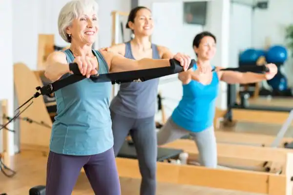 Toning Arms After 60: Empowering Womens Fitness Through Effective Weight Training 2 older woman doing weight training Harrogate and resistance in the gym to tone upper arms