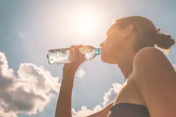 Hydration: The Secret Ingredient for a Toned Stomach and Enhanced Fitness 3 Image of woman drinking water to hydrate Harrogate after run.